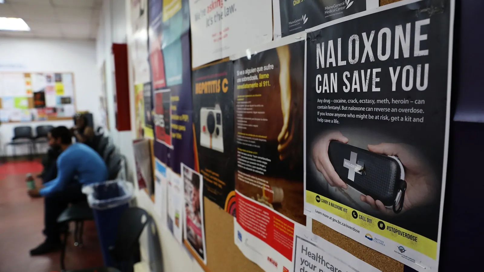 An photo of a bulletin board with a flyer that reads "Naloxone can save you"