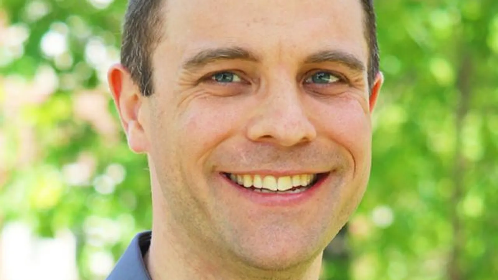 Professor Andre Carrel headshot on green background