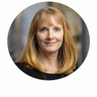 Headshot of Dr. Missy Cummings, with shoulder-length blonde hair, wearing a black top and necklace, against a softly blurred background.