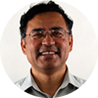 Headshot of Somesh Jha wearing glasses and a collared shirt, smiling against a neutral background.