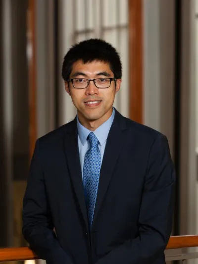 Kaifeng Jiang in a suit smiling at the camera