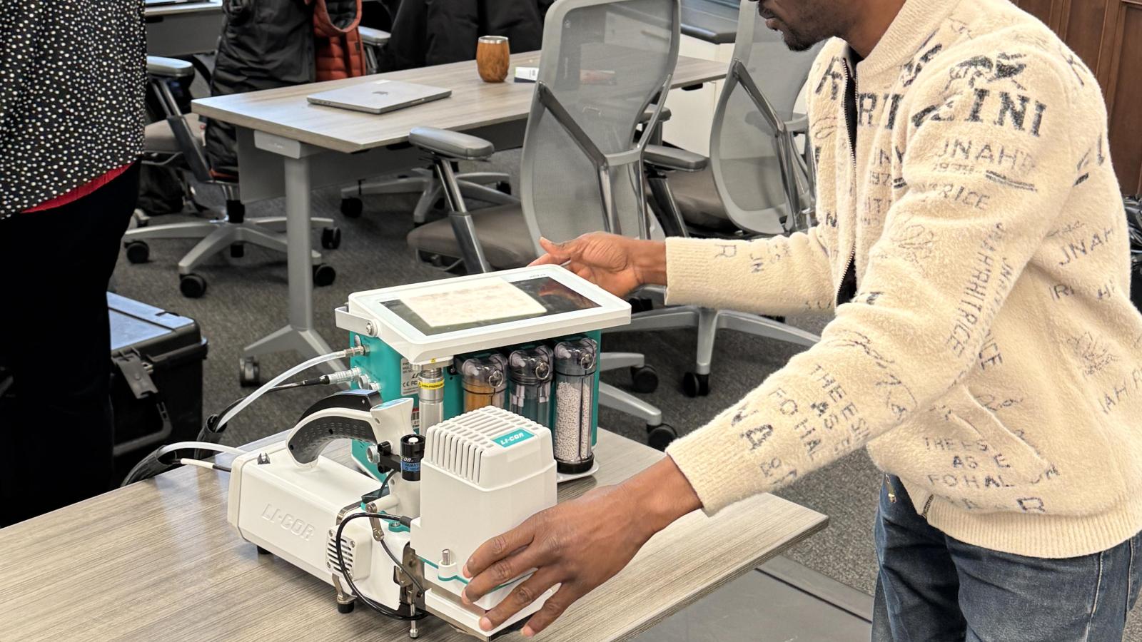 A workshop participant uses a LI-6800 portable photosynthesis system to measure leaf gas exchange during the TDAI-hosted LI-COR training in Pomerene Hall.